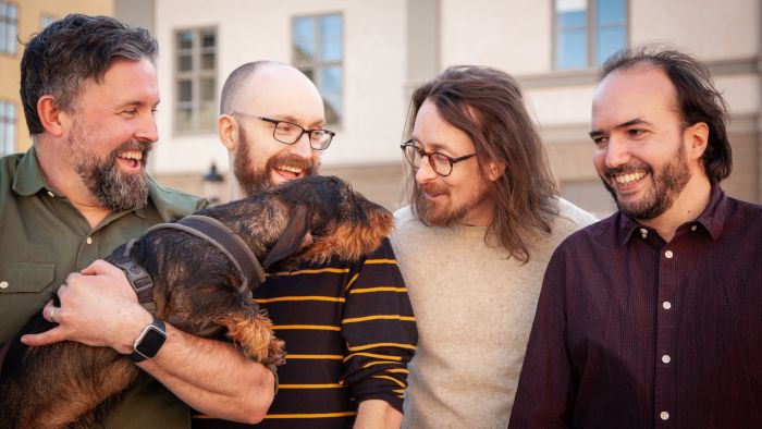 De gauche à droite : Jamie Keen (directeur créatif), Huxley (mascotte), Ben Keen (directeur technique), Christofer Emgard (directeur narratif), Julien Wera (PDG)